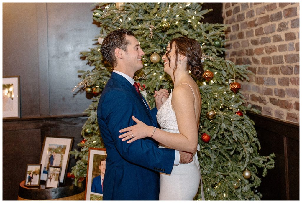 bride and groom in front of christmas tree at olde mecklenberg brewery in charlotte nc