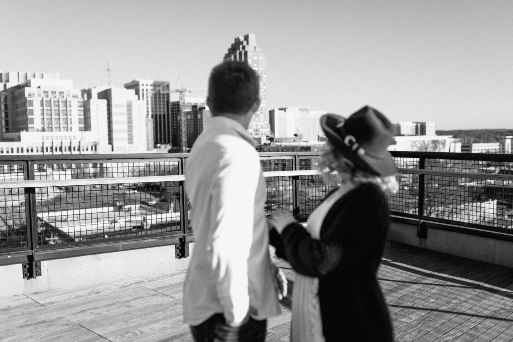 couple looking back at raleigh nc skyline