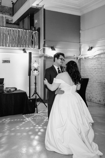 a bride and groom dancing during wedding reception at wilburn lofts in downtown fayetteville