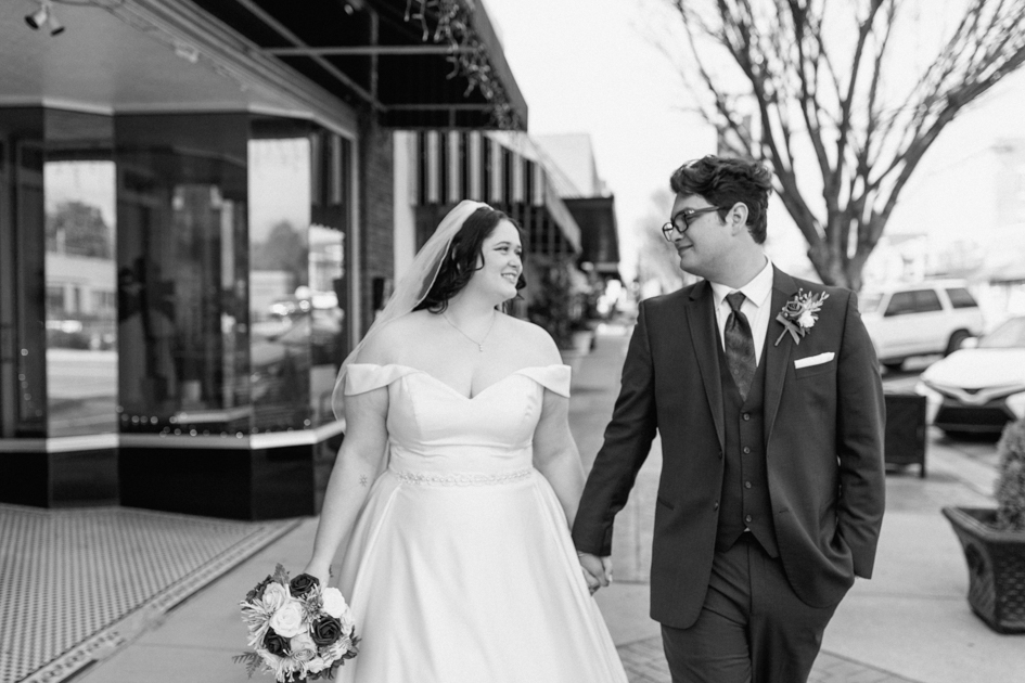 a bride and groom walking pose at downtown fayetteville wedding
